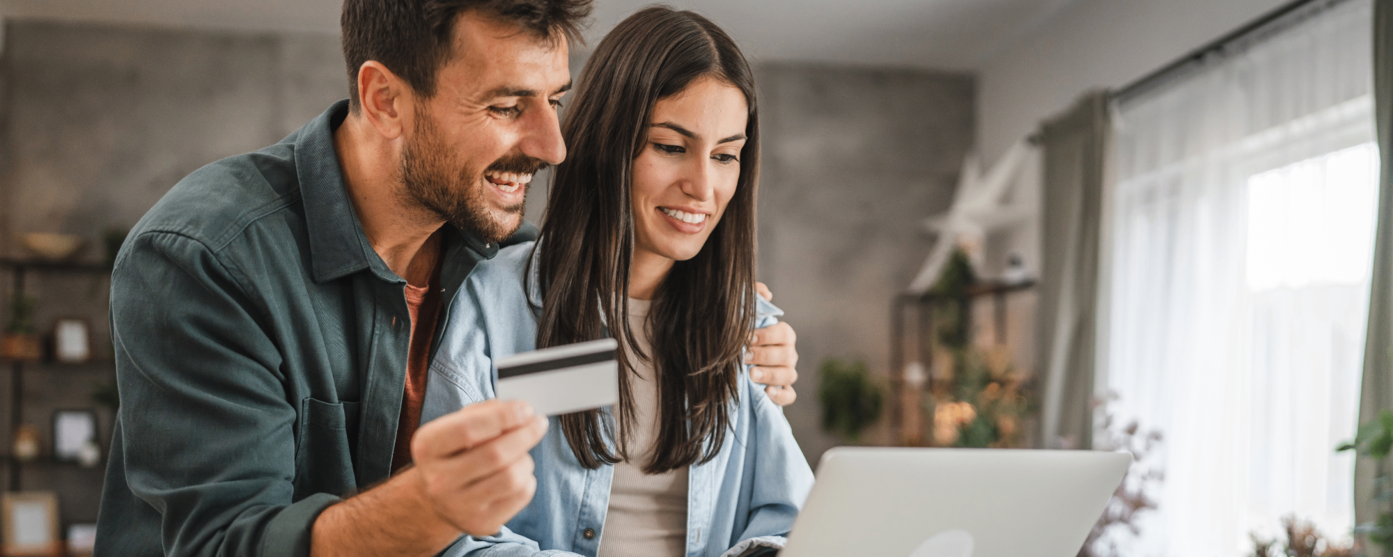 homem e mulher com cartão e usando notebook