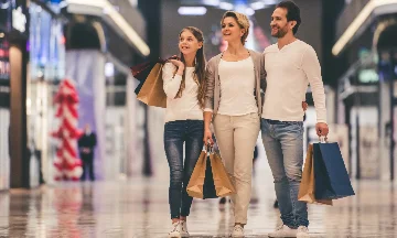 Familia andando com compras em um shopping