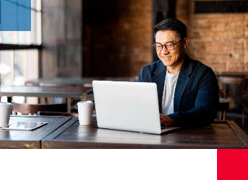Homem trabalhando com um notebook em um café